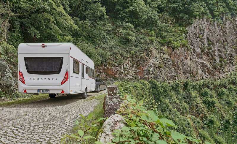 Wohnwagen wird auf einer Gebirgsstraße gezogen