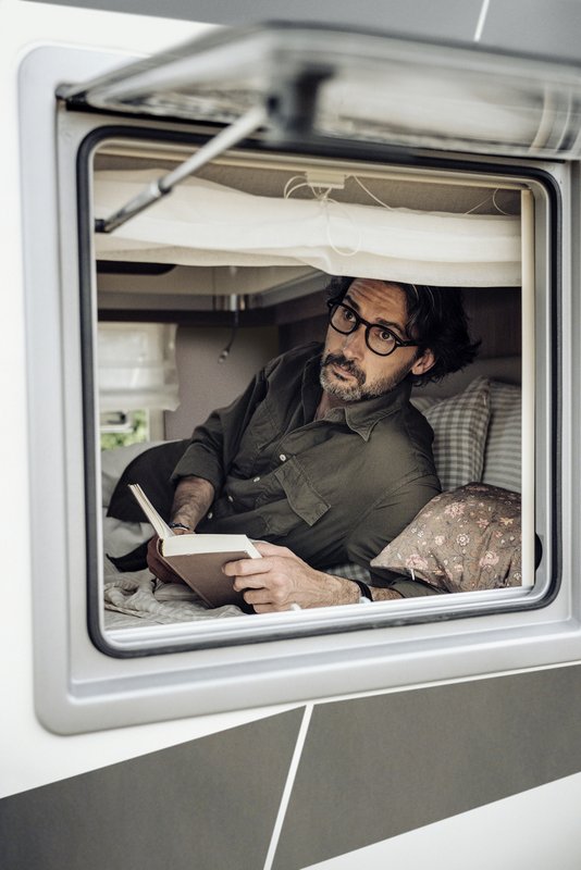 Laika-Reisemobil mit lesendem Mann, der aus dem Fenster schaut 