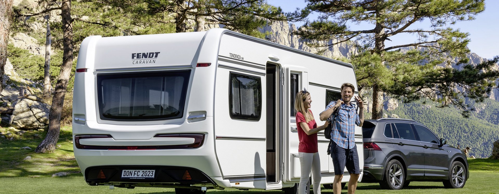 Personen stehen am Fendt Caravan in der Natur 