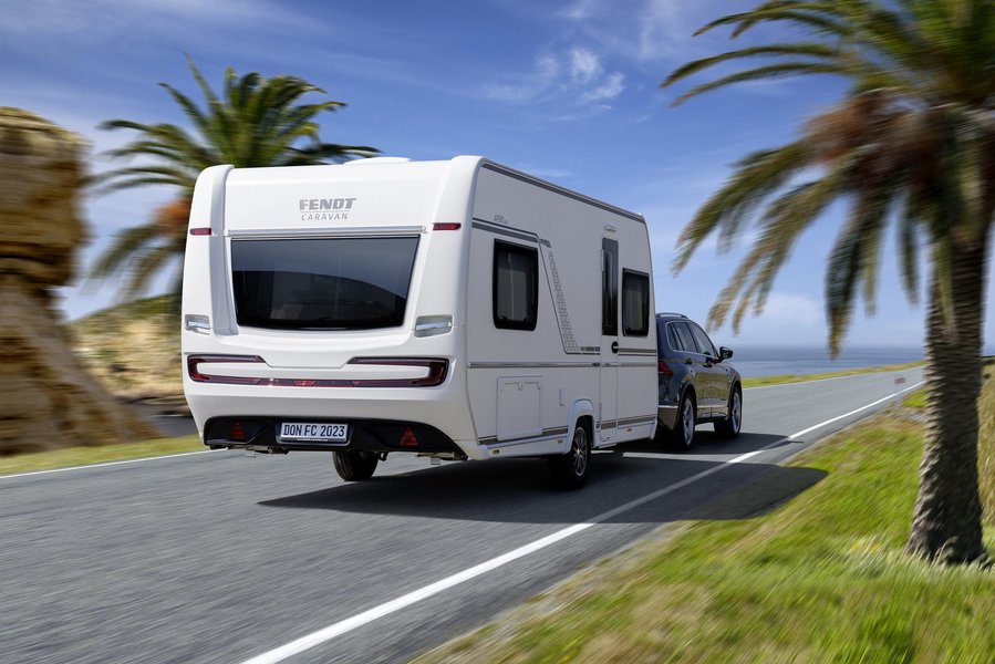 Fendt-Caravan fährt auf der Straße in sonniger Umgebung mit Palmen