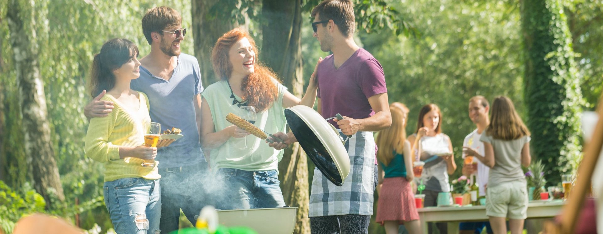 Menschen amüsieren sich und grillen im Freien