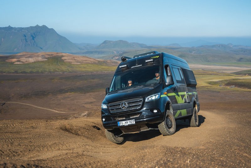 Camper Van fährt durch eine Wüstenlandschaft