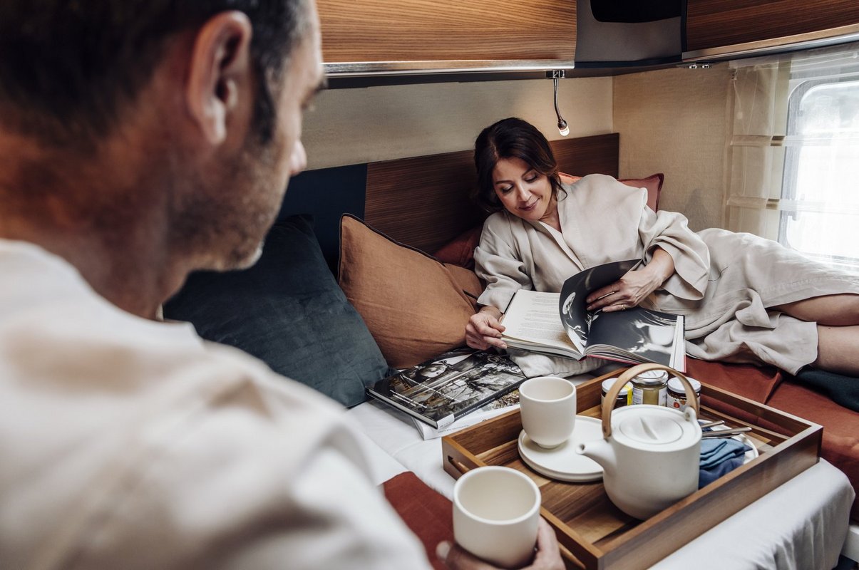 Laika-Reisemobil Inneneinrichtung Schlafbereich mit Paar beim Frühstück
