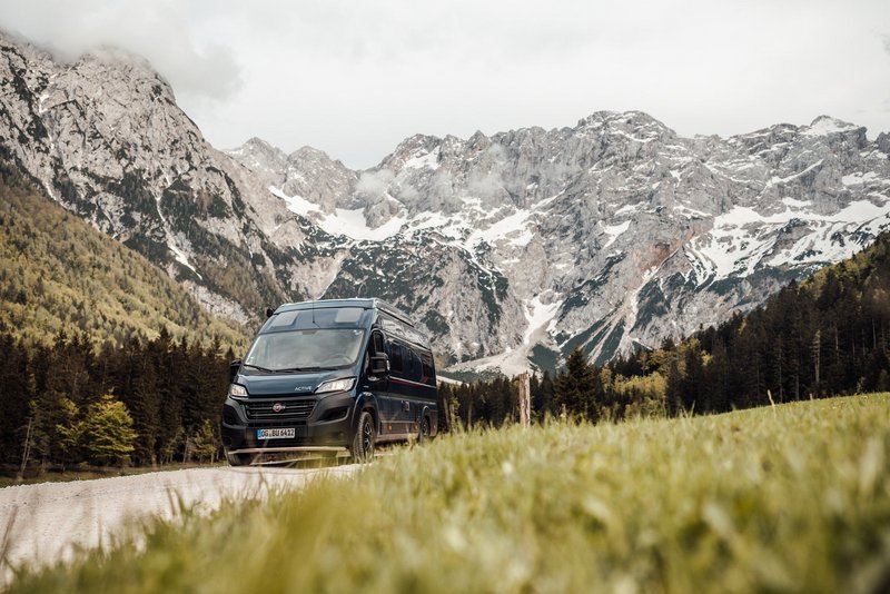 Bürstner Wohnmobil fährt durch eine Landschaft mit Bergen im Hintergrund