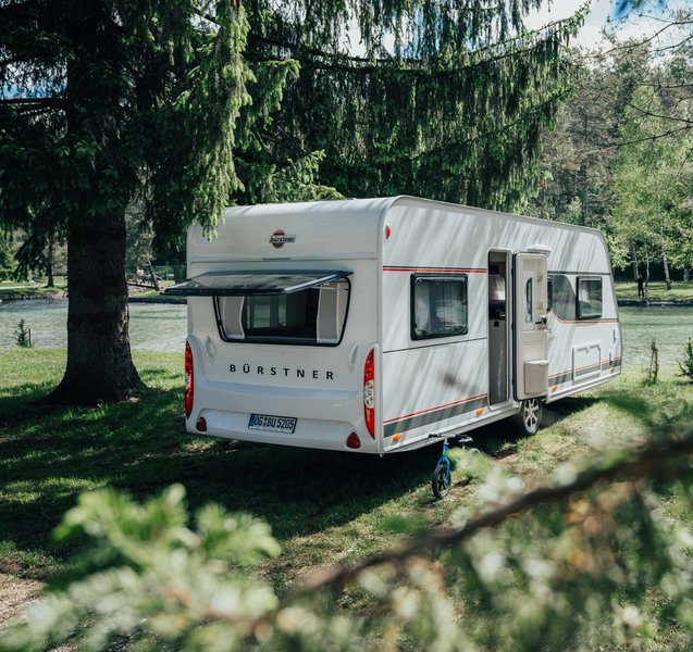 Bürstner Wohnwagen mit geöffnetem Fenster und Tür im Wald 