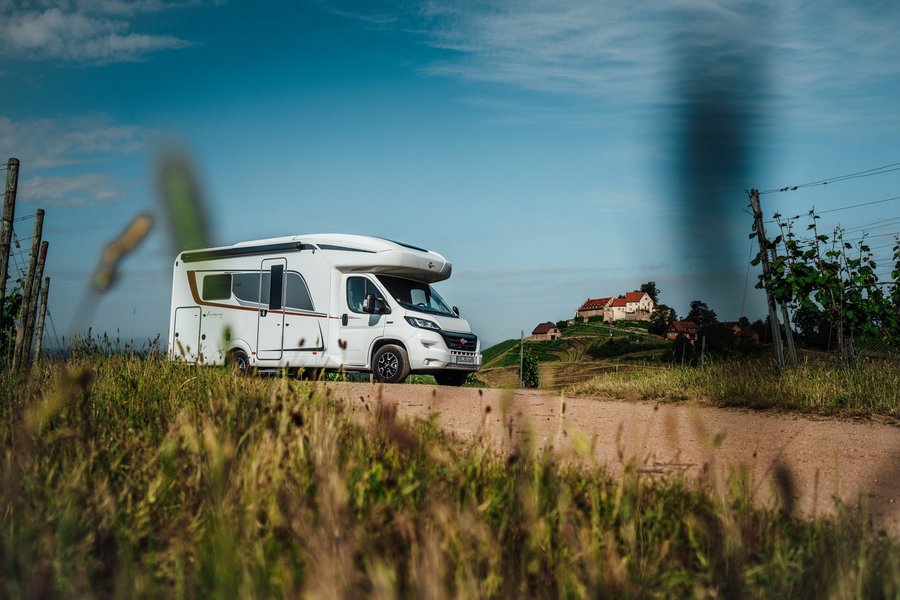 Bürstner Wohnmobil fährt durch eine ländliche Gegend