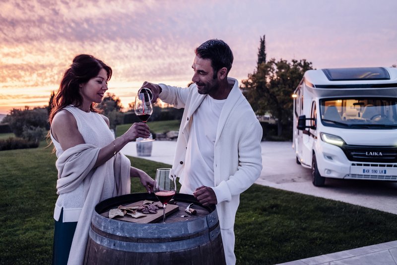 Wohnmobil Laika Kreos, Personen trinken Wein bei Sonnenuntergang