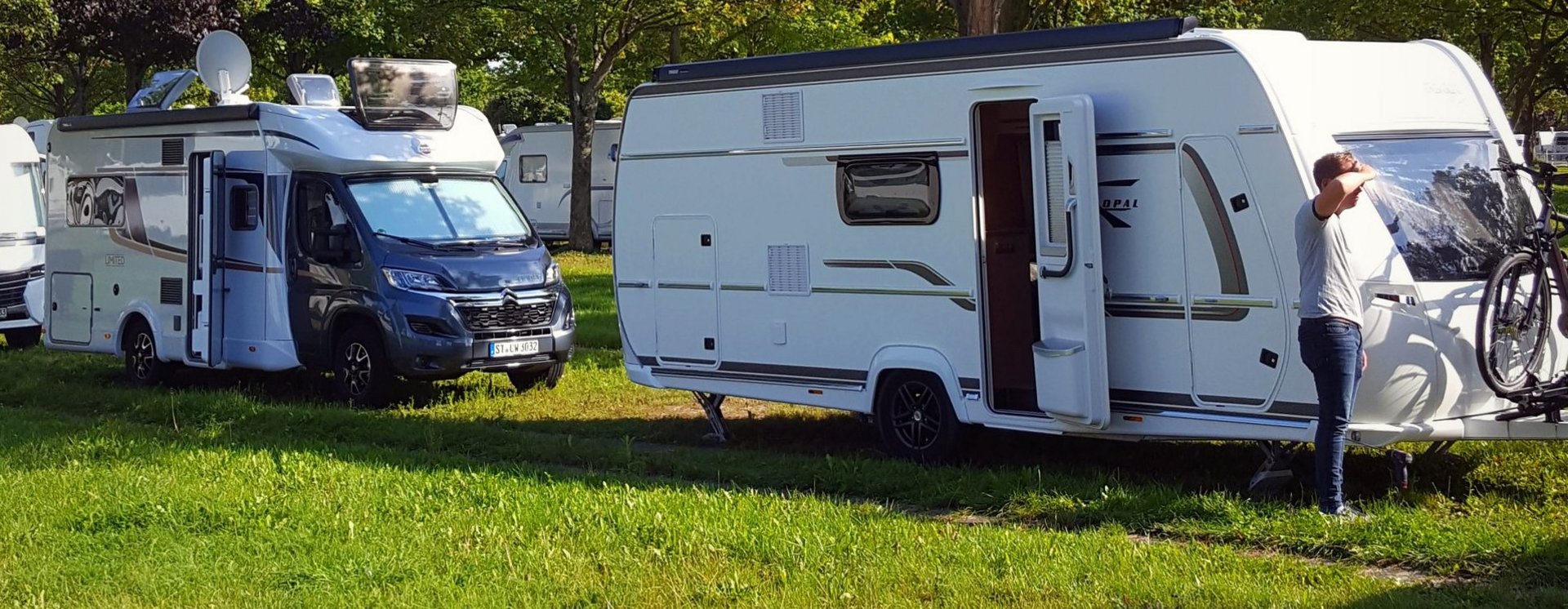 Wohnmobil und Wohnwagen auf einer Wiese