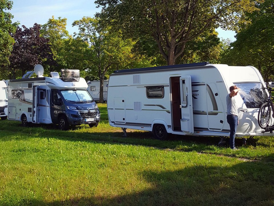 Wohnmobil und Wohnwagen auf einer Wiese