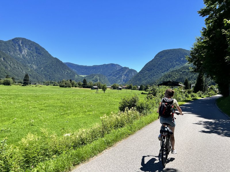 Frau fährt Fahrrad durch grüne Landschaft