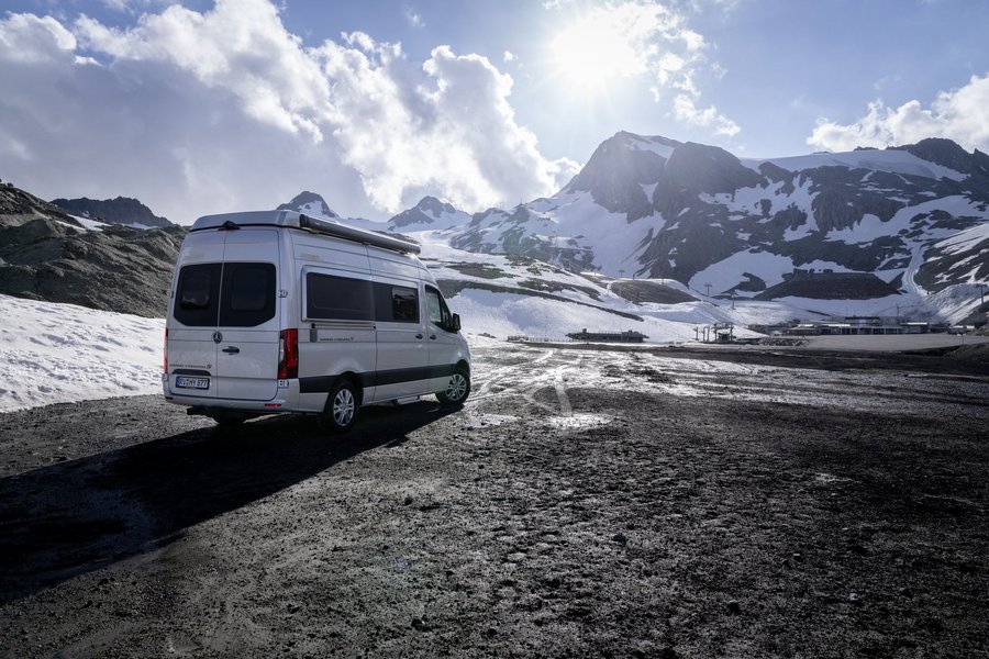 Hymer Camper Van fährt durch verschneites Gebirge