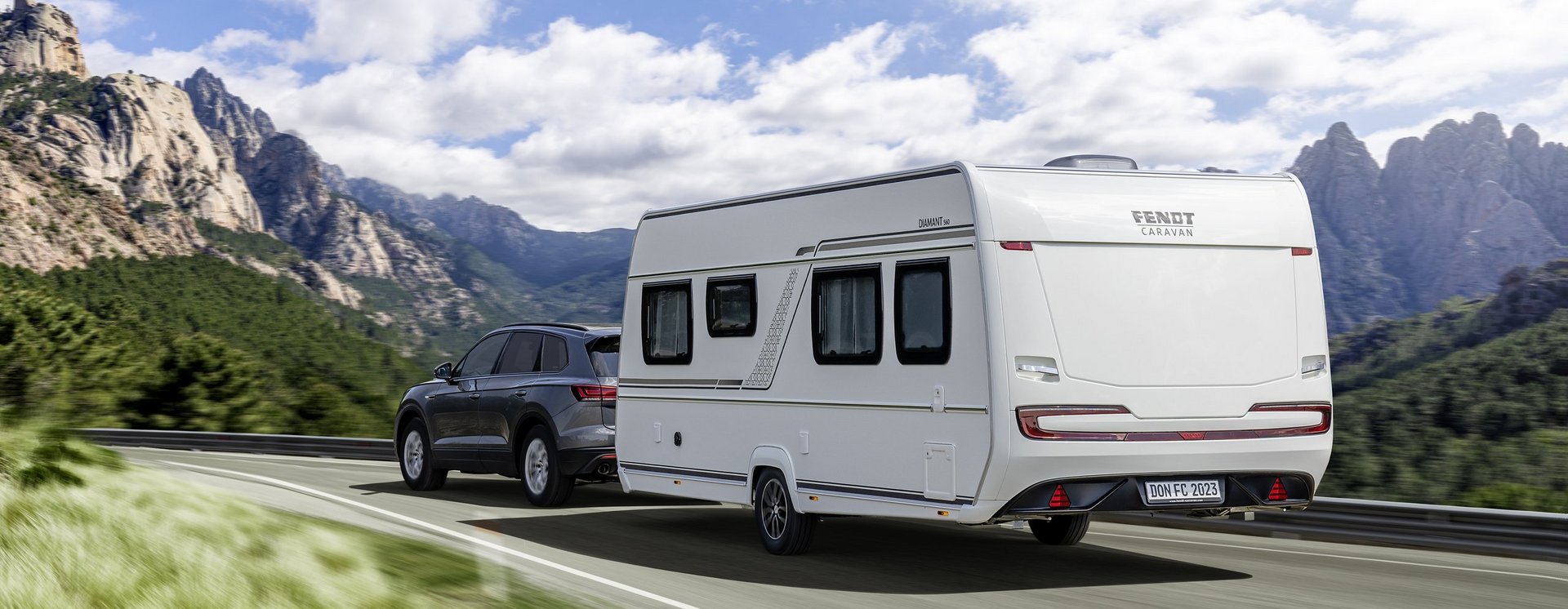 Fendt-Caravan fährt auf der Straße im Gebirge 