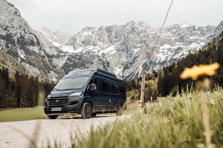 Bürstner Wohnmobil fährt durch eine Landschaft, Berge und Wald