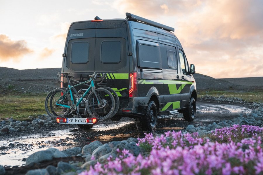 Hymer Camper Van fährt auf Schlammstraße durch die Natur